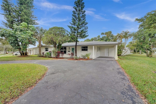 ranch-style house featuring a carport and a front lawn