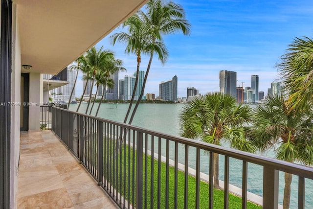 balcony with a water view and a view of city