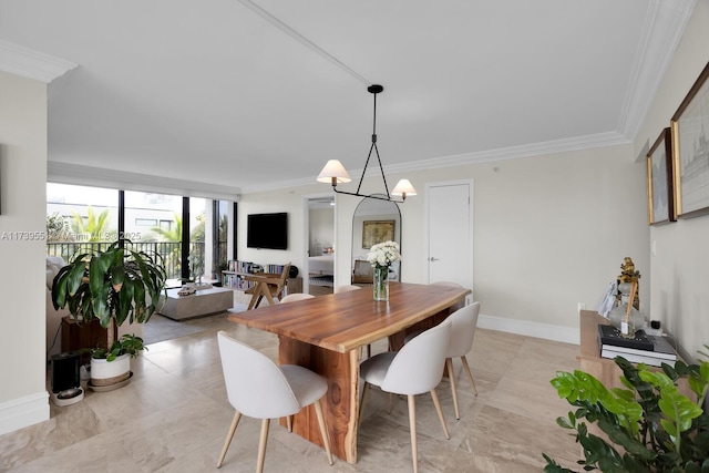 dining room featuring baseboards, a chandelier, and crown molding