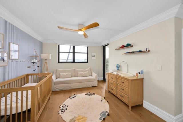 bedroom featuring light wood finished floors, baseboards, ornamental molding, and a ceiling fan