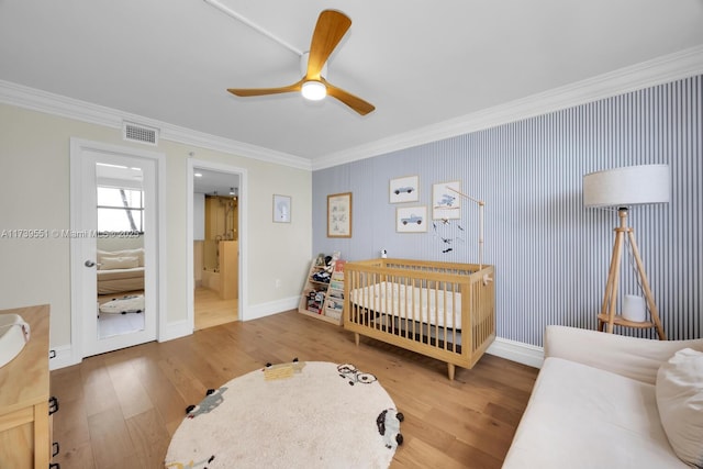 bedroom with crown molding, visible vents, and wood finished floors