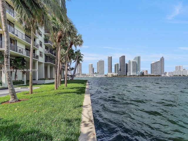 exterior space with a water view, a lawn, and a city view