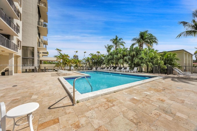 pool with a patio area and fence