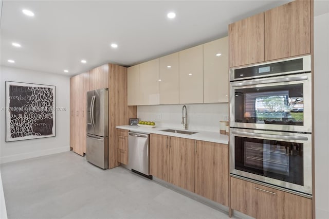 kitchen featuring recessed lighting, a sink, light countertops, appliances with stainless steel finishes, and modern cabinets