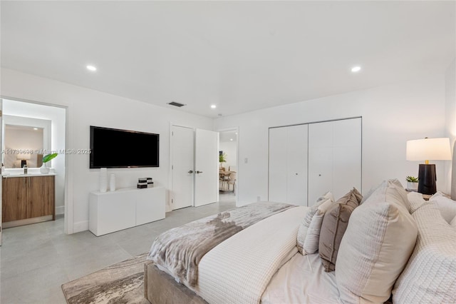 bedroom featuring ensuite bath, concrete floors, visible vents, and recessed lighting