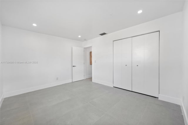 unfurnished bedroom with a closet, recessed lighting, visible vents, and baseboards