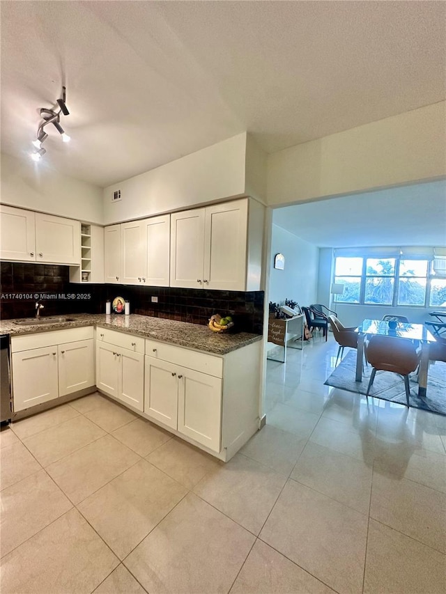 kitchen with white cabinetry, stainless steel dishwasher, tasteful backsplash, and light tile patterned floors