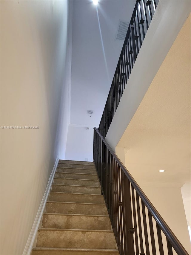 staircase featuring visible vents and baseboards