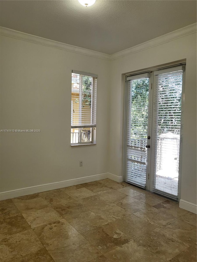 spare room featuring french doors, baseboards, a textured ceiling, and crown molding