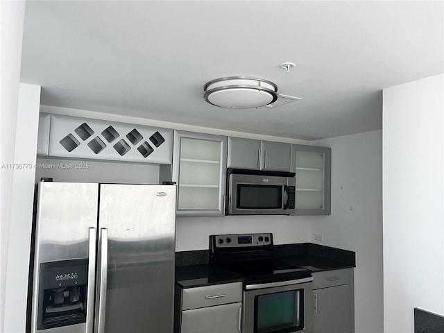 kitchen featuring gray cabinets and appliances with stainless steel finishes