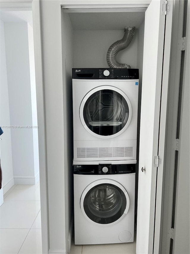 laundry room with stacked washer / drying machine and light tile patterned floors