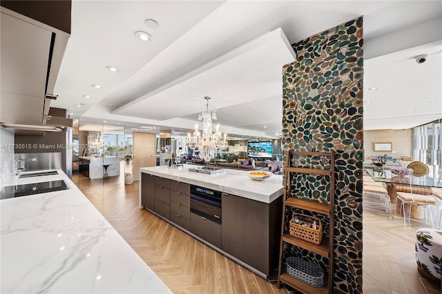 kitchen featuring light stone counters, black electric stovetop, dark brown cabinets, and light parquet floors