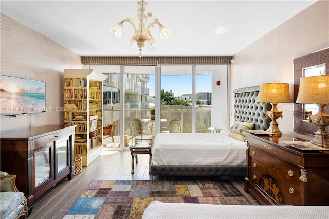 bedroom with a fireplace, wood-type flooring, a chandelier, access to outside, and floor to ceiling windows