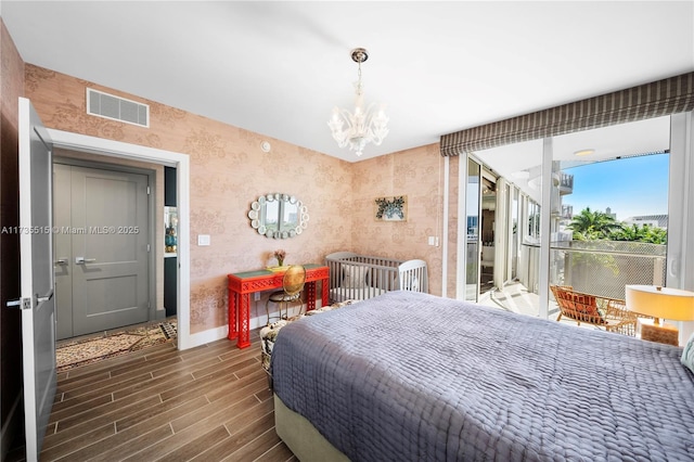 bedroom featuring a notable chandelier and dark wood-type flooring