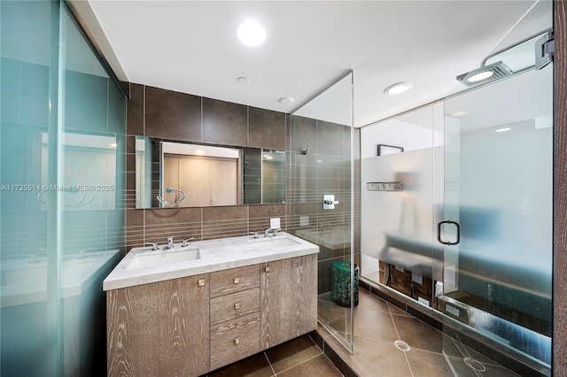 bathroom with tile walls, decorative backsplash, vanity, walk in shower, and tile patterned floors