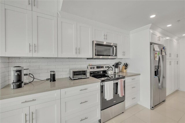 kitchen with white cabinetry, light tile patterned floors, tasteful backsplash, and stainless steel appliances