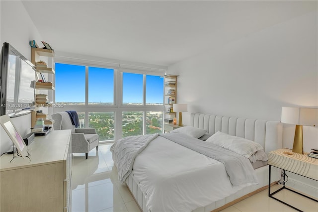 bedroom with light tile patterned flooring and a wall of windows