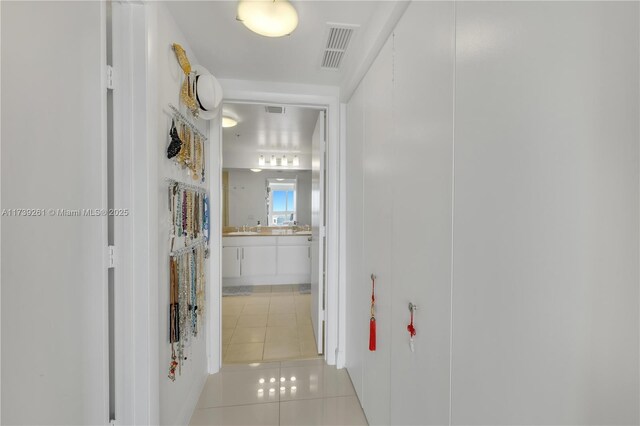 corridor with light tile patterned floors and sink