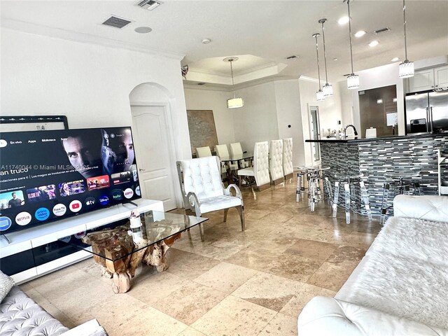 living room featuring crown molding and a tray ceiling