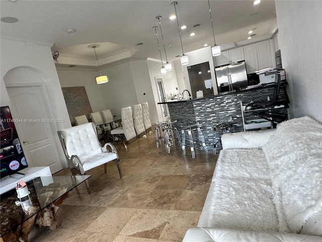 living room featuring ornamental molding and a raised ceiling