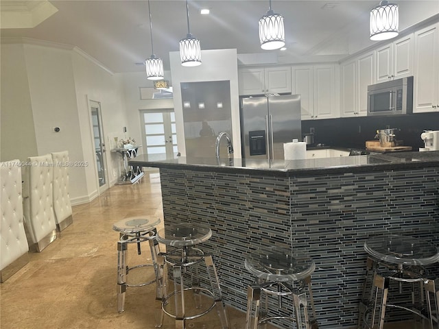 kitchen featuring stainless steel appliances, pendant lighting, white cabinets, and french doors