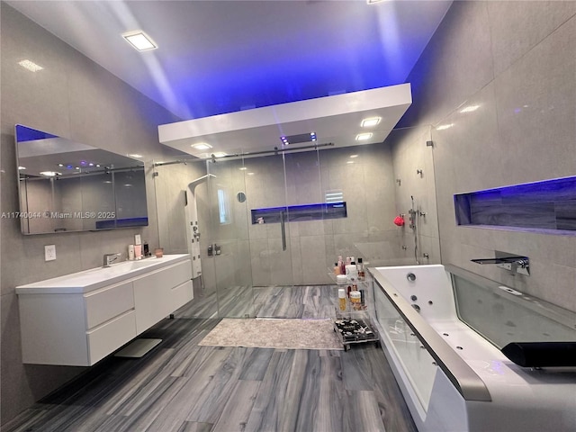 bathroom featuring vanity, plus walk in shower, and hardwood / wood-style floors