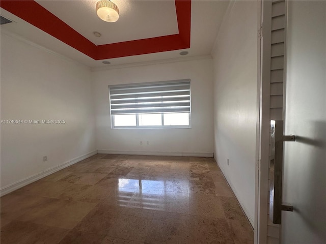 unfurnished room featuring crown molding and a raised ceiling