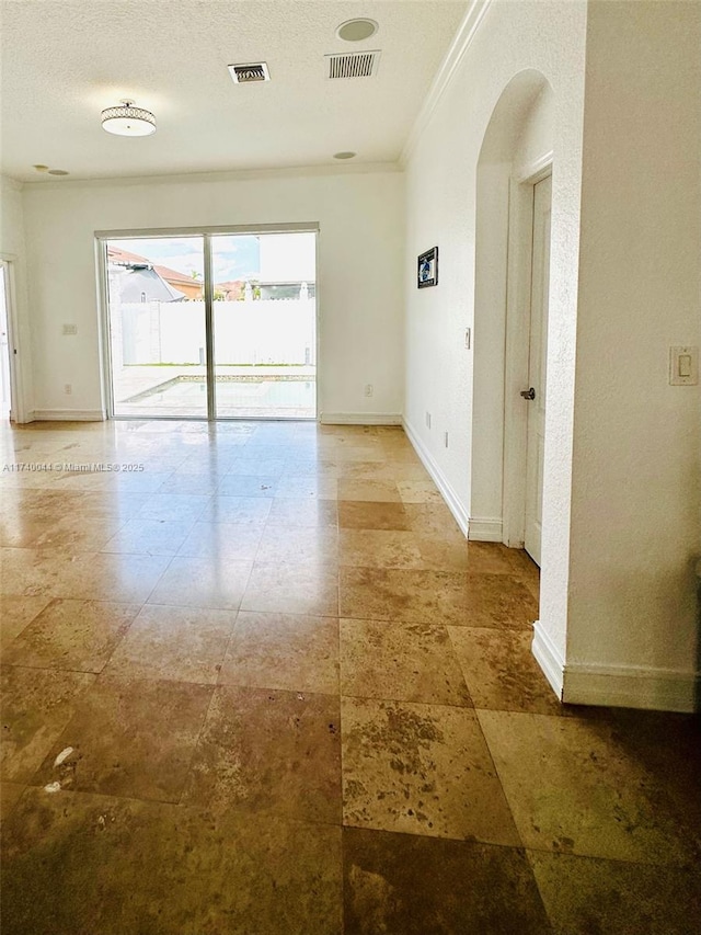 unfurnished room featuring ornamental molding and a textured ceiling