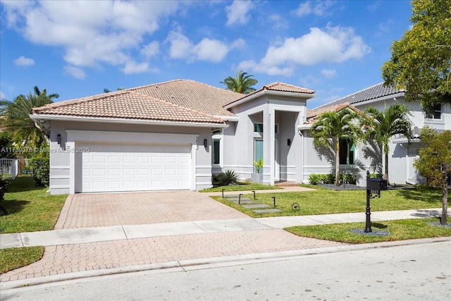 mediterranean / spanish house featuring a garage and a front yard