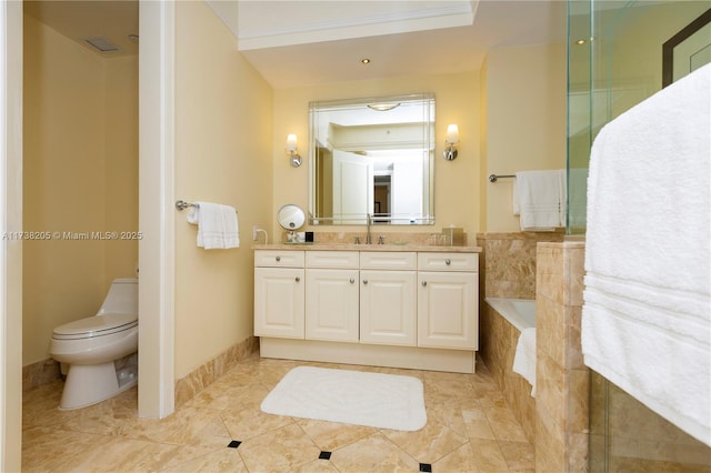 bathroom with a relaxing tiled tub, vanity, and toilet