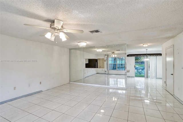 unfurnished room with ceiling fan, a textured ceiling, and light tile patterned floors