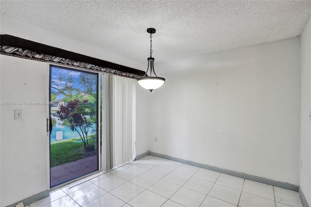 unfurnished dining area featuring a textured ceiling and light tile patterned flooring