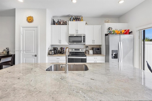 kitchen featuring sink, light stone countertops, and appliances with stainless steel finishes