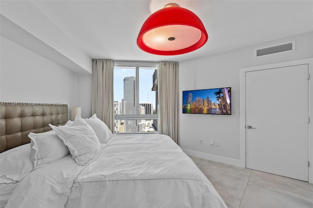 bedroom featuring visible vents, baseboards, and light tile patterned floors