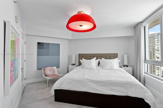 bedroom with concrete flooring and baseboards