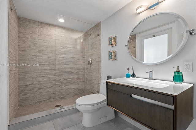 full bath featuring tile patterned flooring, tiled shower, vanity, and toilet