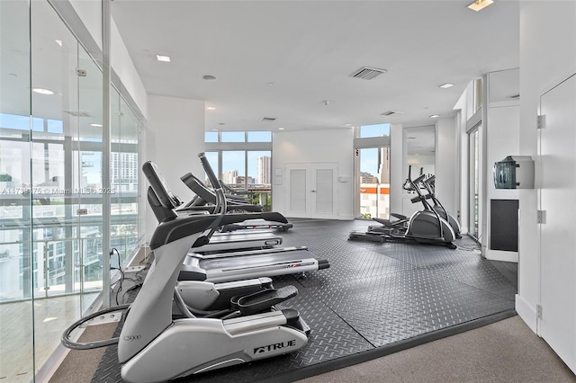 exercise room featuring a city view and visible vents