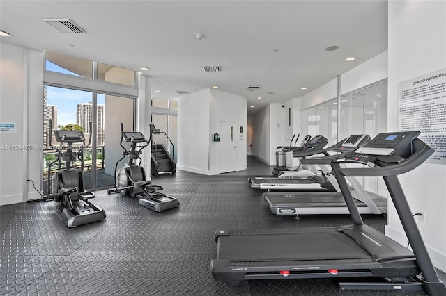 workout area featuring baseboards, a view of city, and visible vents