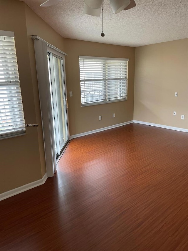 empty room with hardwood / wood-style flooring, a textured ceiling, and ceiling fan