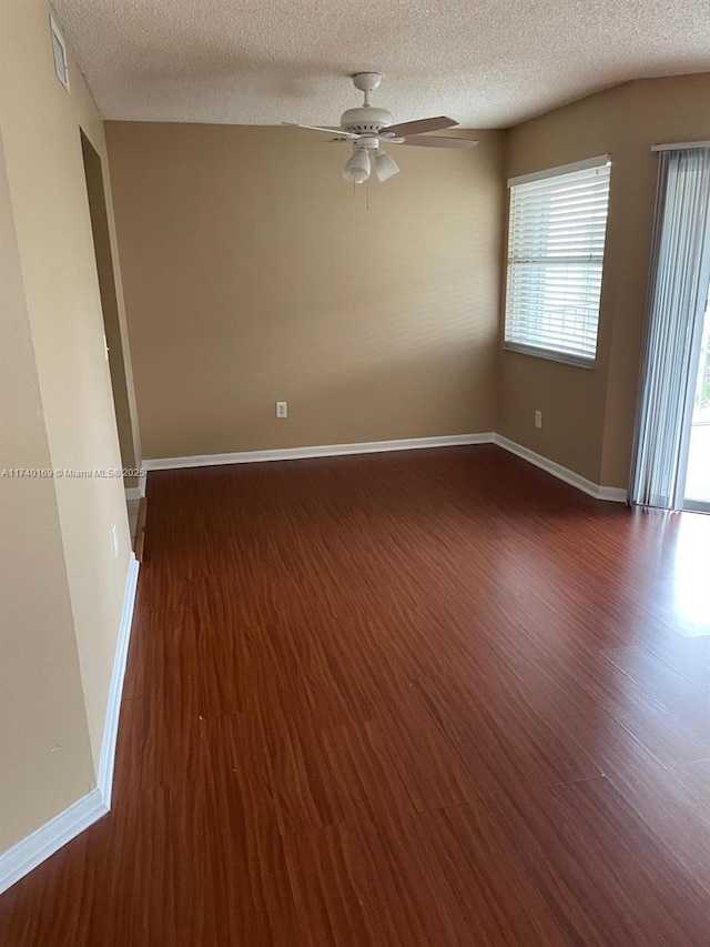 unfurnished room with ceiling fan, dark hardwood / wood-style floors, and a textured ceiling