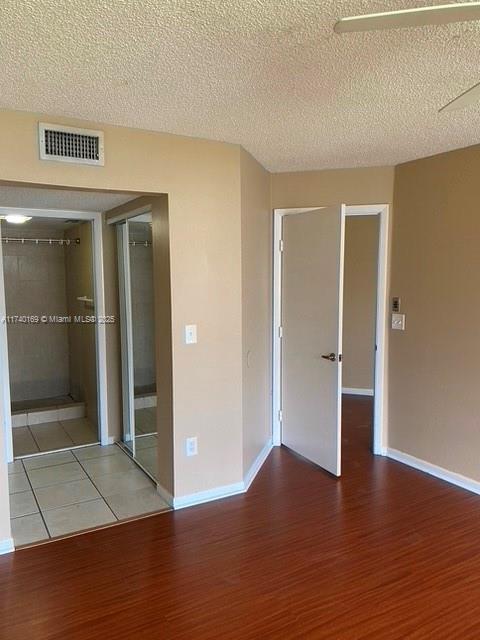 empty room with hardwood / wood-style flooring and a textured ceiling