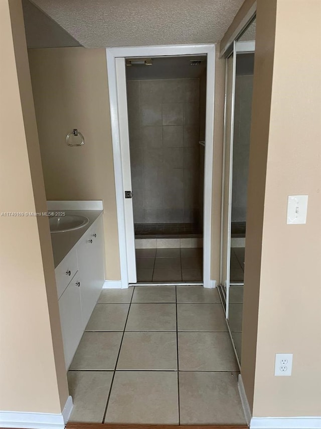 bathroom featuring vanity, tile patterned flooring, and a textured ceiling