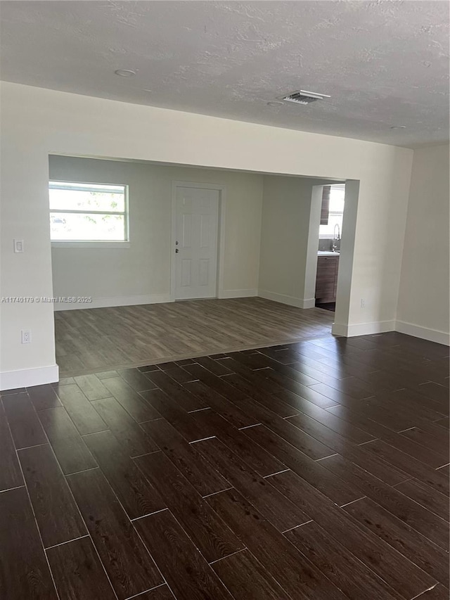 empty room featuring dark hardwood / wood-style floors and a textured ceiling