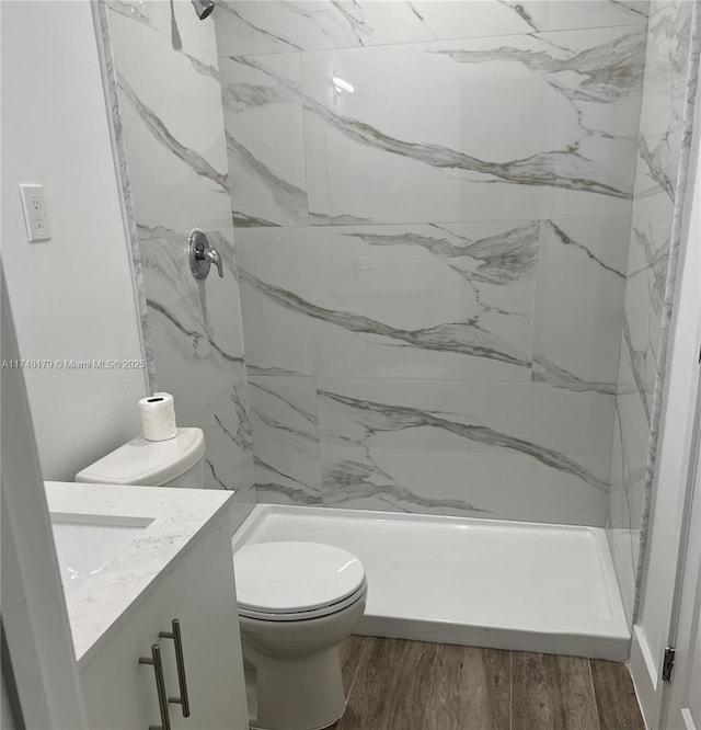 bathroom featuring vanity, hardwood / wood-style floors, and a tile shower