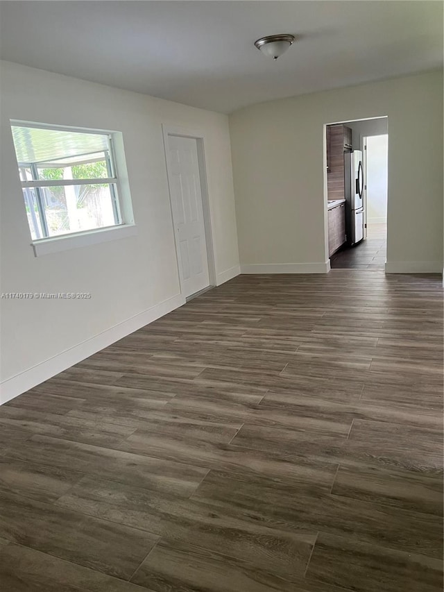 spare room with dark wood-type flooring