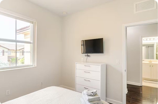 bedroom featuring multiple windows, sink, and dark hardwood / wood-style flooring