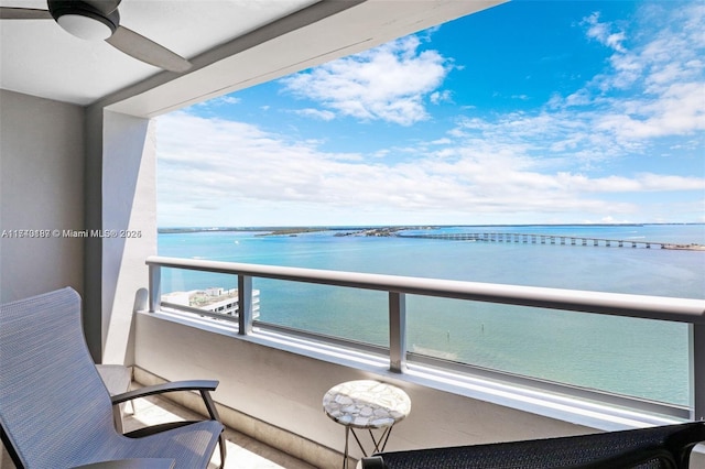 balcony with ceiling fan and a water view