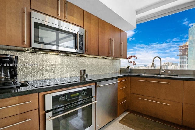 kitchen featuring appliances with stainless steel finishes, sink, and decorative backsplash