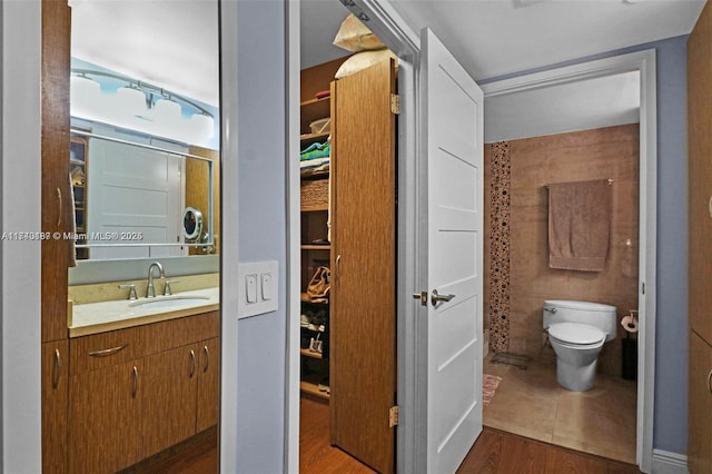 bathroom with vanity, toilet, and hardwood / wood-style floors