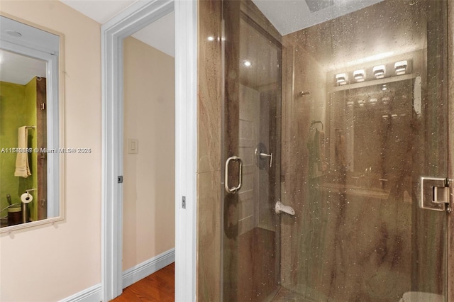 bathroom featuring wood-type flooring and a shower with door